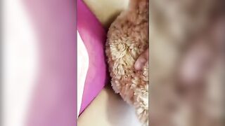 A girl is having fun with a teddy bear, mimicking intimate acts