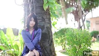 An Asian girl plays with her pussy in the garden and squirts