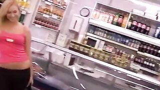 A stunning blonde woman tries to take some cash from the cashier