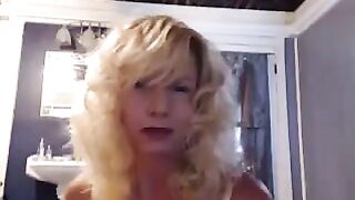 A mature woman caresses herself in the bathroom with a toy