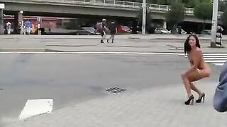 A sexy brunette with a nice body poses in public