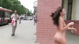 A sexy brunette with a nice body poses in public