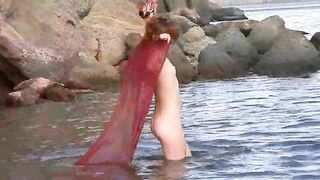 A small boobed nudist gets wet and horny in the rain