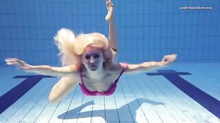 A naked woman is swimming in the pool, showcasing her body