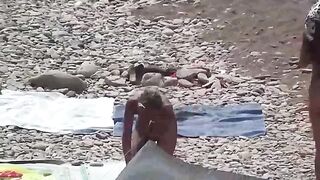 Nudist couple have fun on the beach and show affection