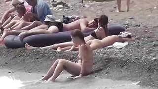 Nudist couple have fun on the beach and show affection