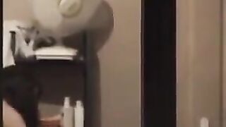 He admires himself naked in the mirror, completely bare
