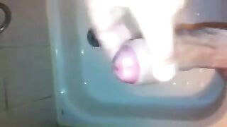 The kid caresses his dick with his hand in the shower stream