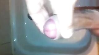 The kid caresses his dick with his hand in the shower stream