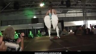 A hot brunette girl is learning to striptease on a pole with passion