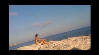 A very nice girl is basking in the sun completely naked