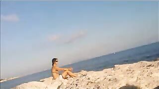 A very nice girl is basking in the sun completely naked