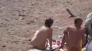 A group of naked girls playing in the sea and getting wet